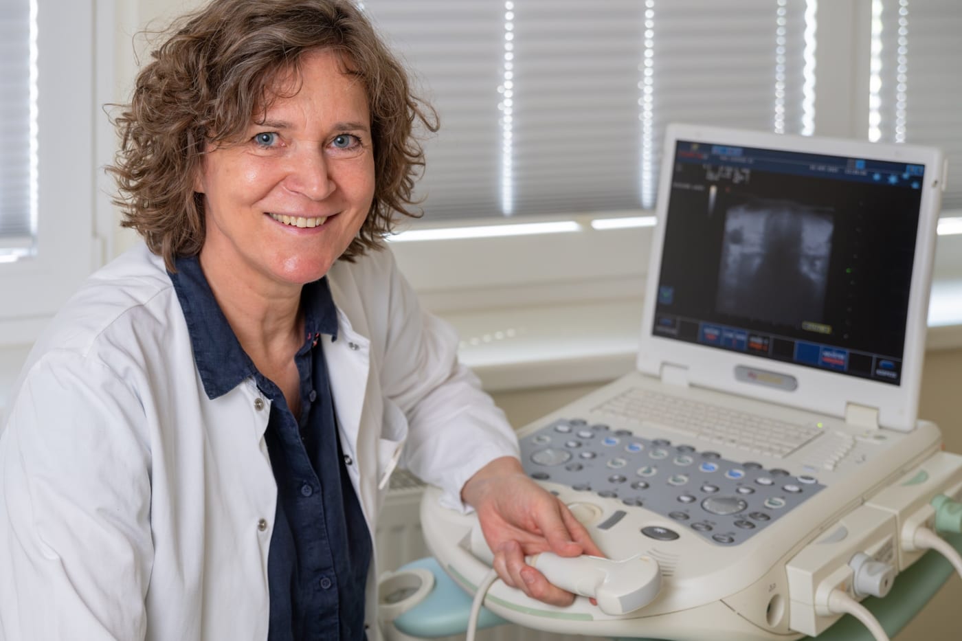 Dr. med. Caren Kaisers bei einer Ultraschalluntersuchung, Schallkopf in der Hand, Monitor mit Aufnahme