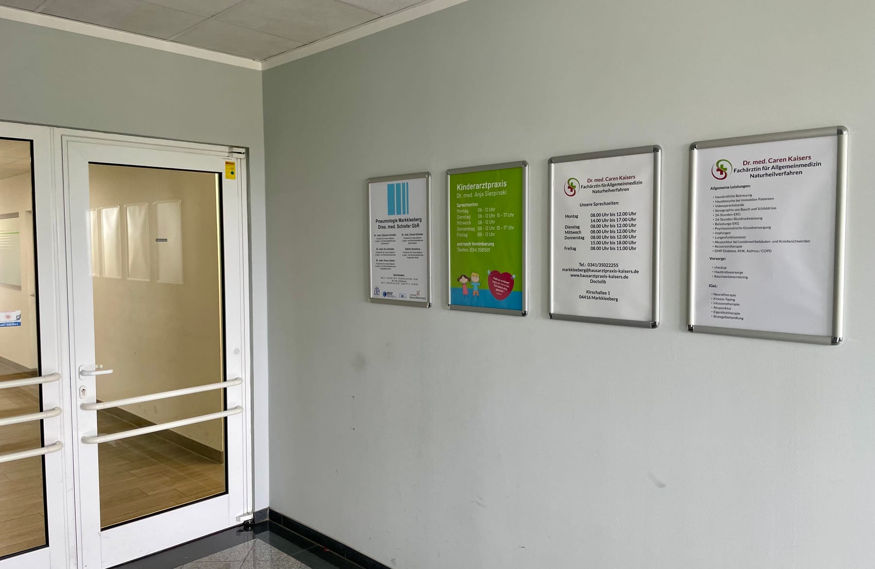 Eingangsbereich im Gebäude mit Hinweisschildern zur Hausarztpraxis Dr. med. Caren Kaisers